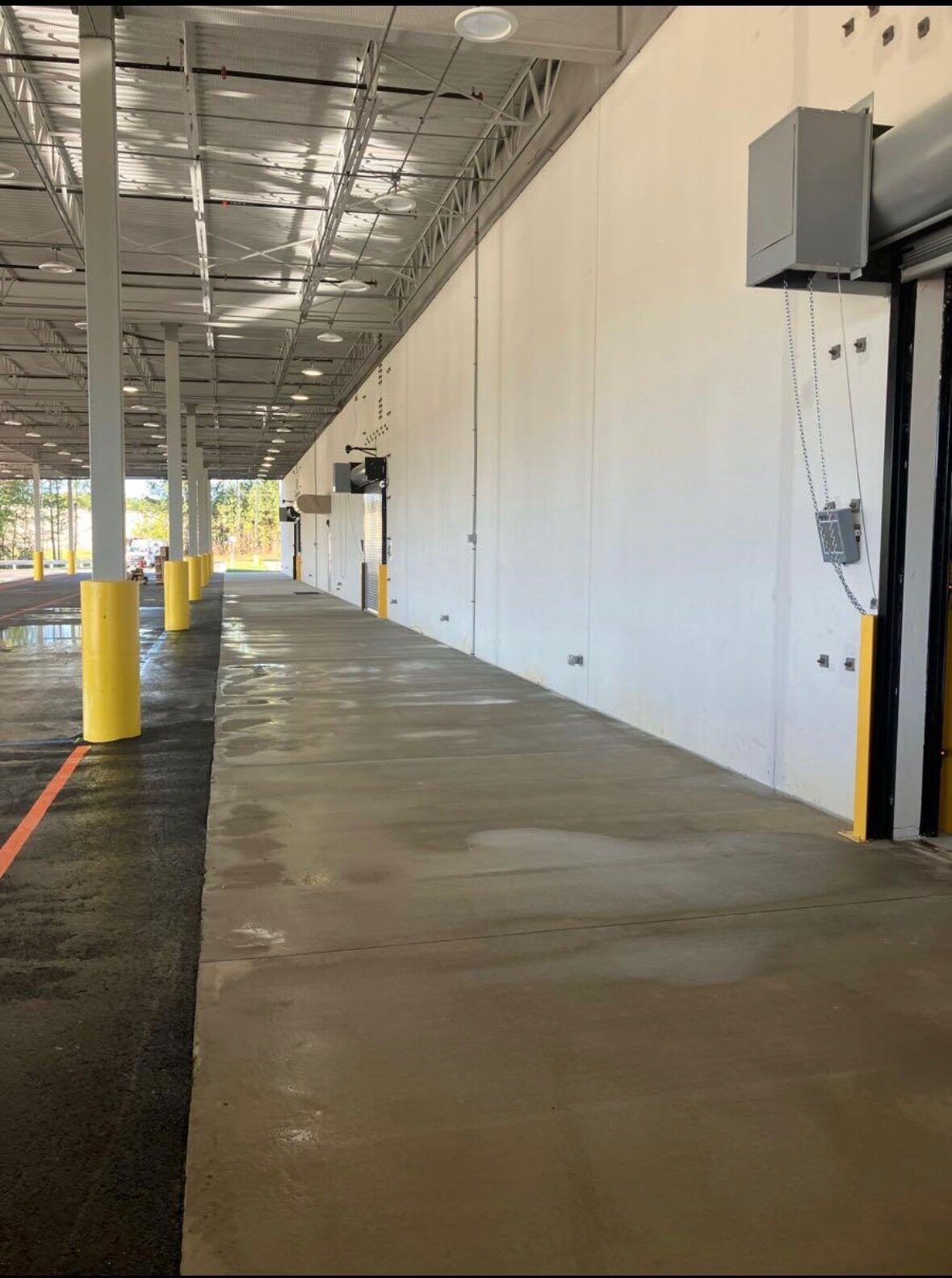 Clean commercial loading dock concrete and exterior wall after pressure washing